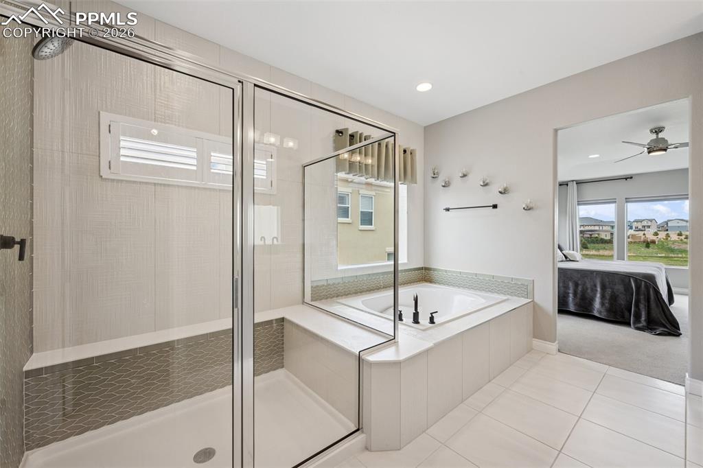 Image 24 of 46: Bathroom featuring a shower stall, ensuite bathroom, tile patterned floors,