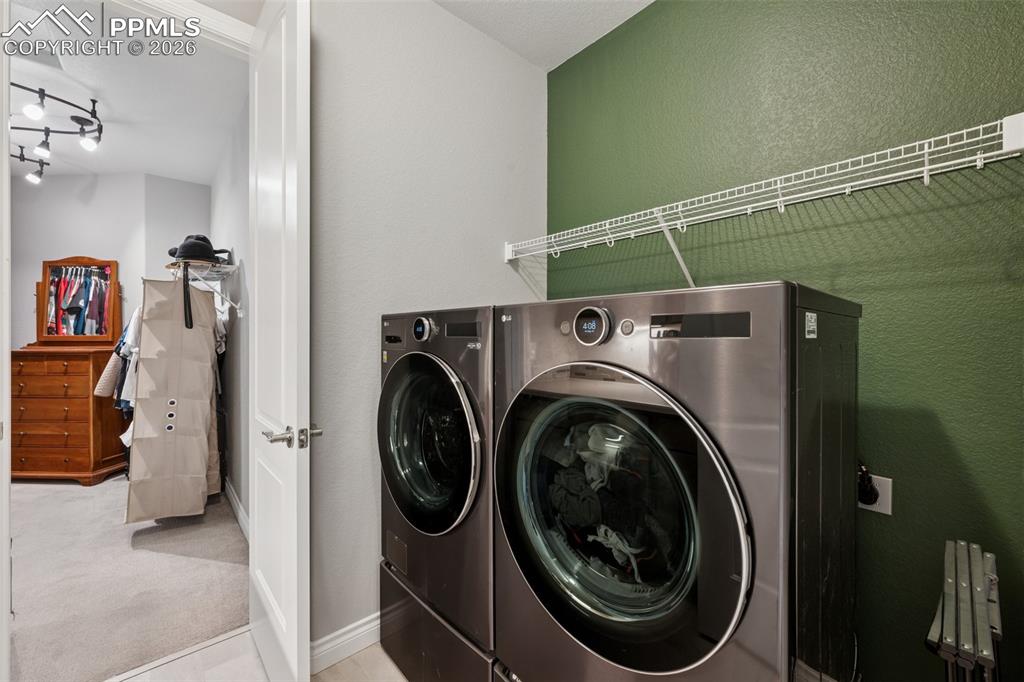 Image 25 of 46: Washroom with carpet, independent washer and dryer, a textured wall, basebo