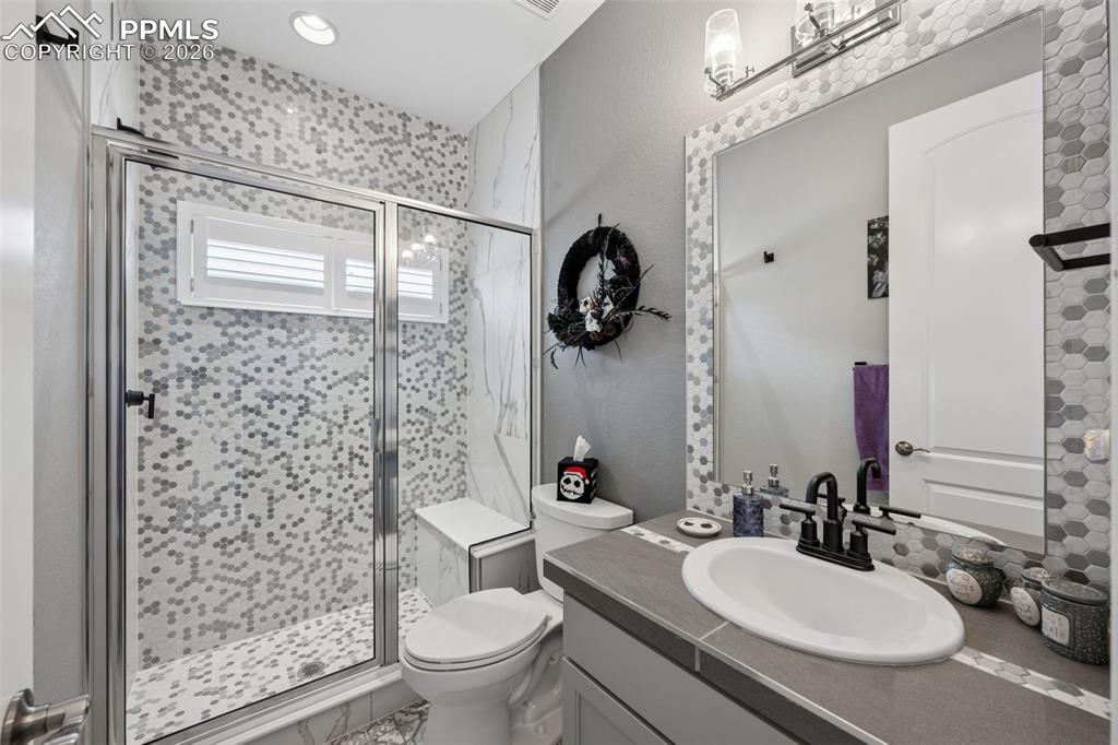 Image 29 of 46: Full bathroom with toilet, a shower stall, and vanity