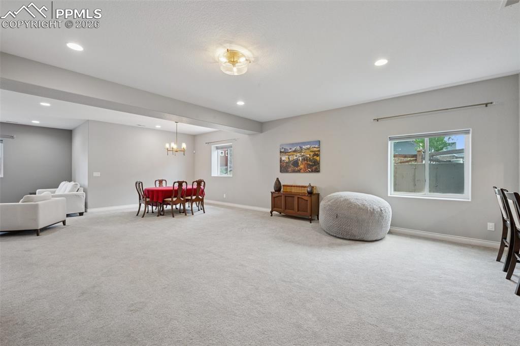 Image 32 of 46: Dining room with carpet flooring, baseboards, recessed lighting, and a chan