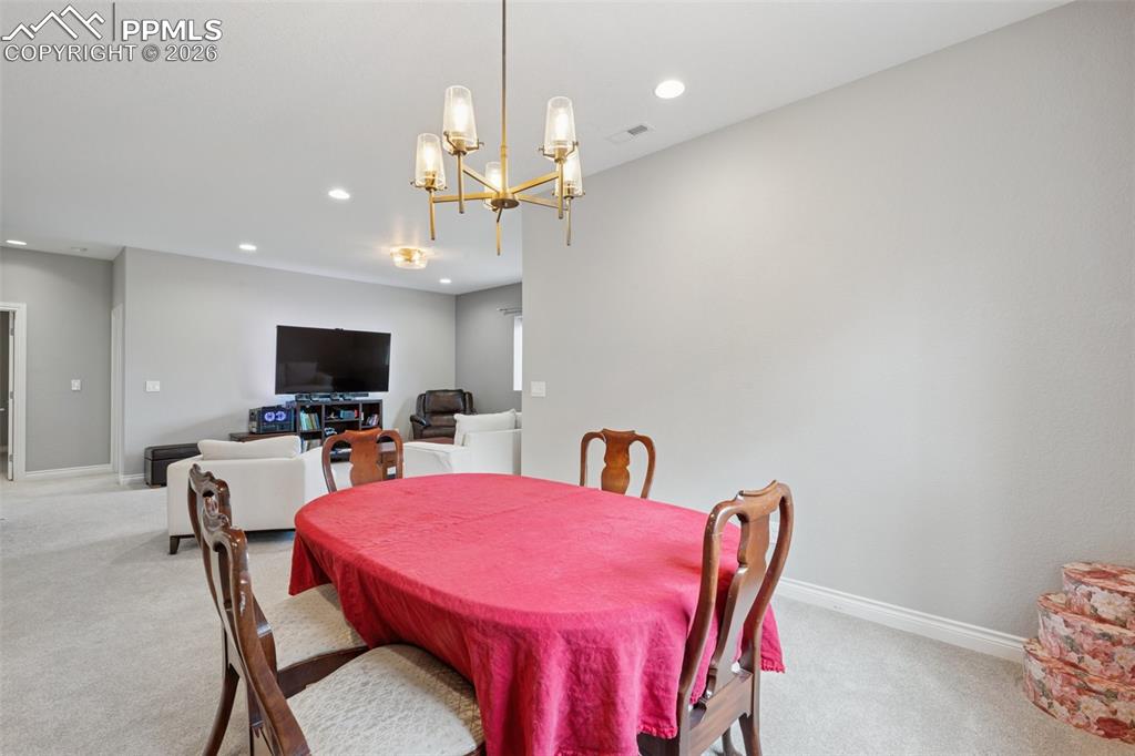 Image 34 of 46: Dining room featuring light carpet, a chandelier, recessed lighting, and ba