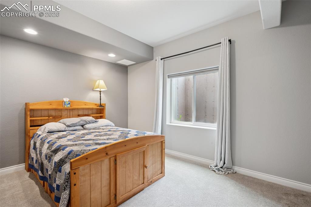 Image 42 of 46: Bedroom with light colored carpet, baseboards, and recessed lighting