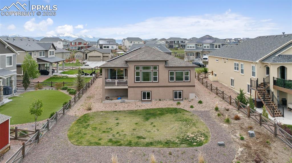 Image 7 of 46: Rear view of house featuring a residential view, a fenced backyard, stairs,