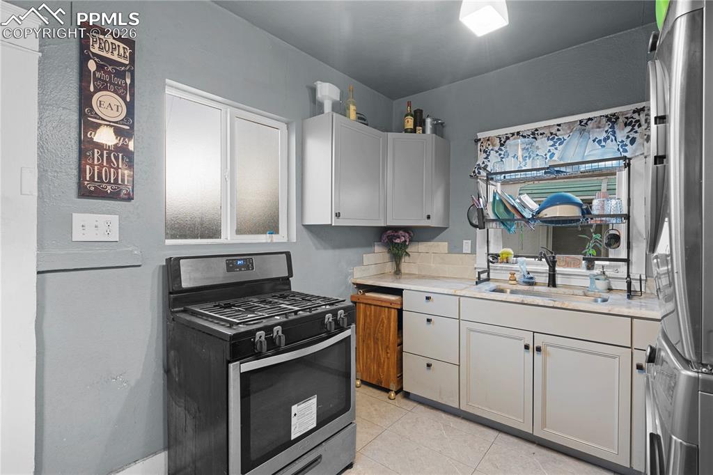 Image 12 of 18: Kitchen featuring stainless steel appliances, light tile patterned floors, 