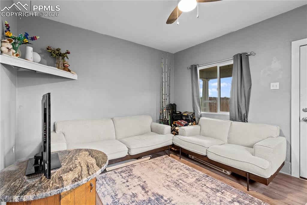 Image 13 of 18: Living room with ceiling fan and wood finished floors
