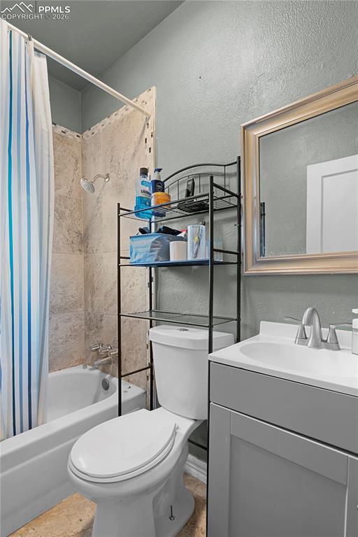 Image 18 of 18: Full bathroom with shower / tub combo with curtain, vanity, and a textured 