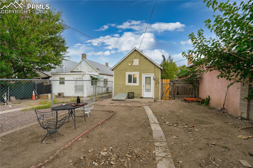 Image 5 of 18: Back of house featuring a gate, a patio, and a fenced backyard