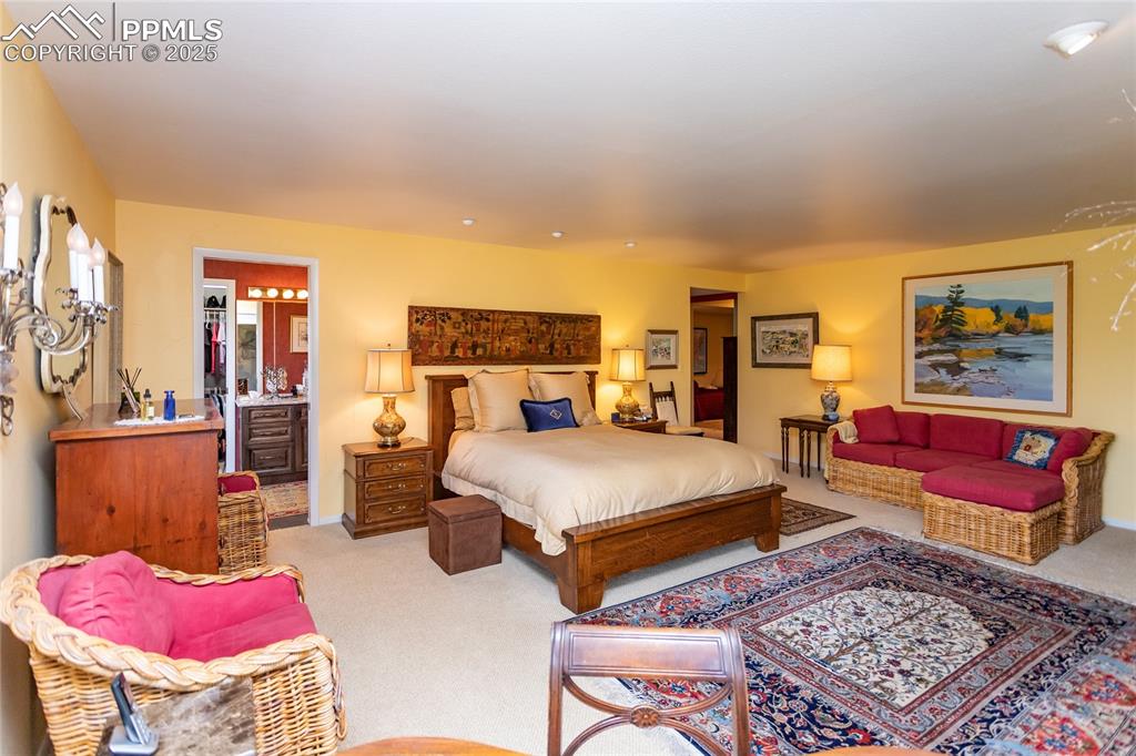 Image 17 of 46: Bedroom with light carpet and connected bathroom