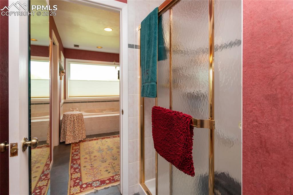 Image 21 of 46: Bathroom featuring a stall shower and a garden tub