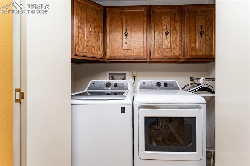 Image 24 of 46: Laundry room with washer and dryer and cabinet space