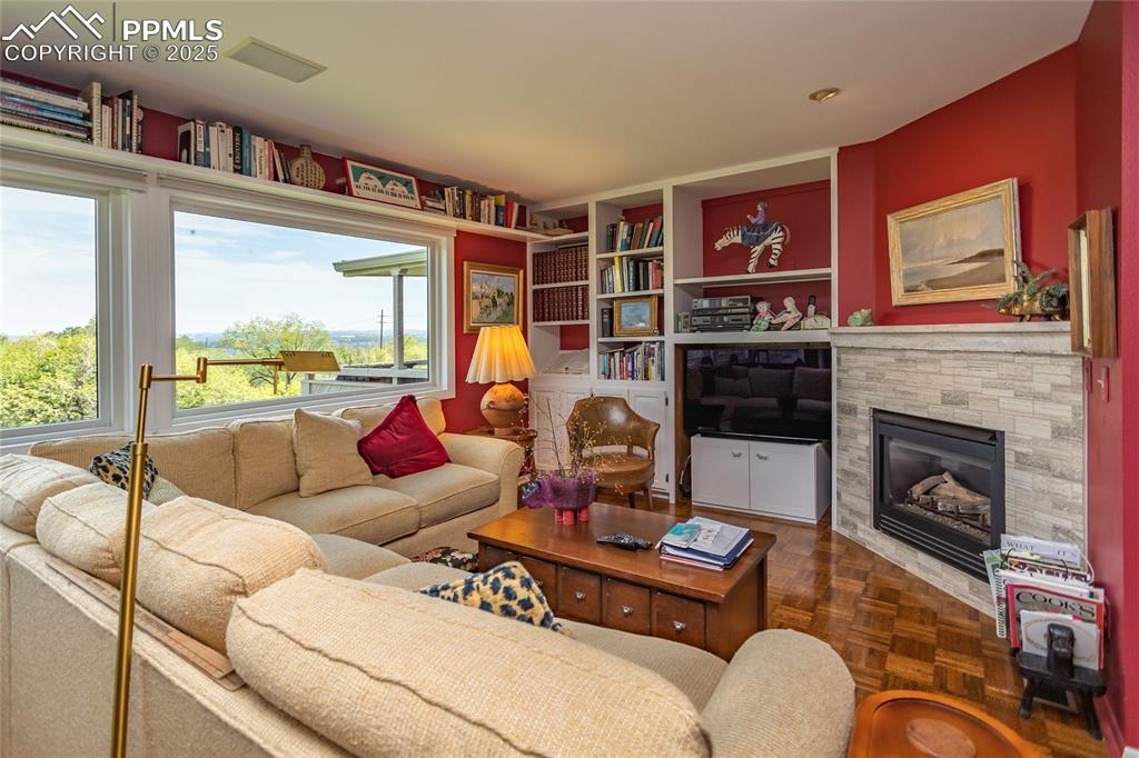 Image 5 of 46: Living area with a fireplace and built in features