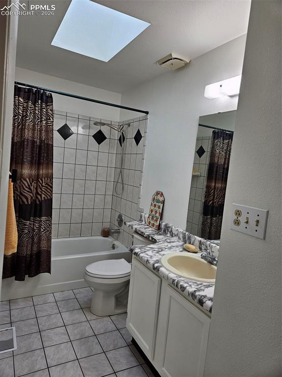 Image 17 of 35: Upper Full bathroom featuring a skylight, shower / bathtub combination