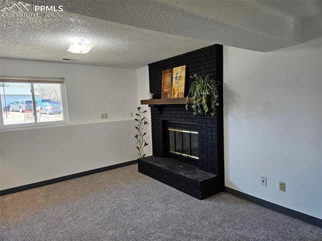 Image 20 of 35: Wood burning fireplace in lower level