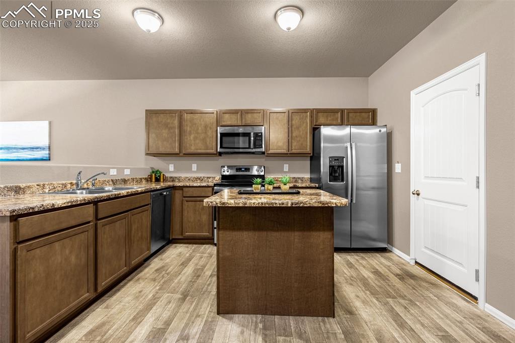 Image 6 of 19: Stainless appliances, well-placed island and easy access to garage
