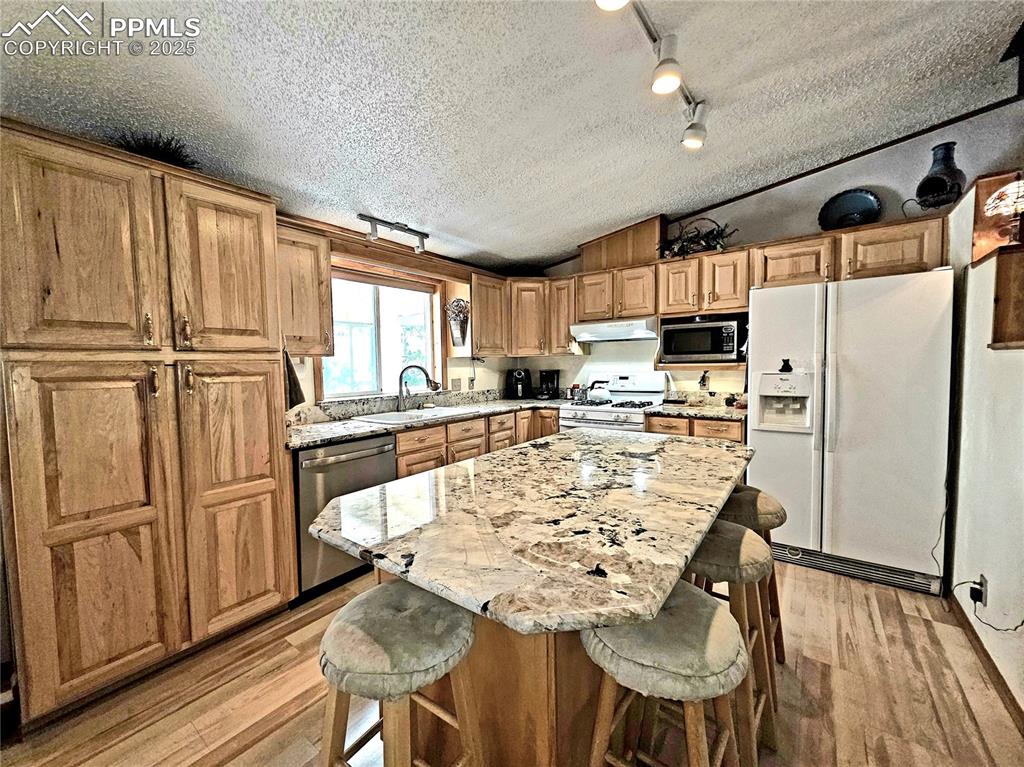 Image 13 of 50: Beautiful granite island in center of the kitchen can seat many