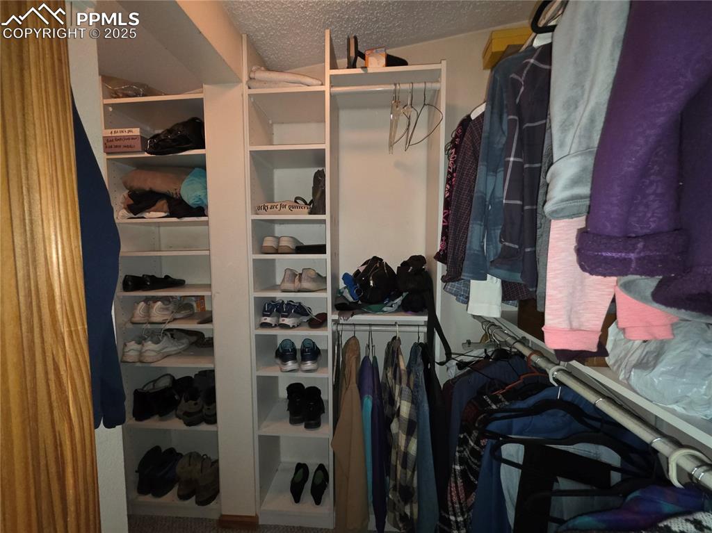 Image 21 of 50: Primary bed walk in closet has plenty of hanging space and shelves for all 