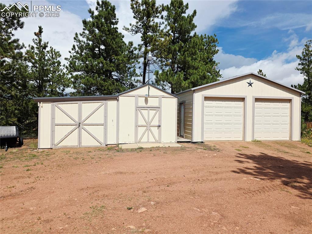 Image 36 of 50: 2 car garage to the right with auto openers and window, one car to the left