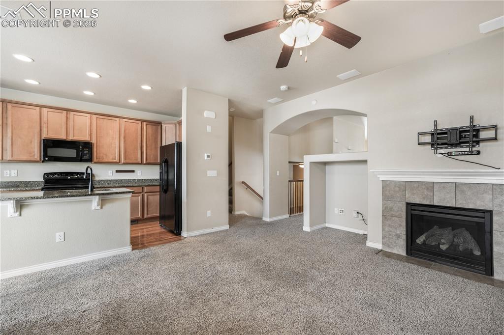 Image 18 of 50: Family room with fas fireplace, access to kitchen and walk out deck