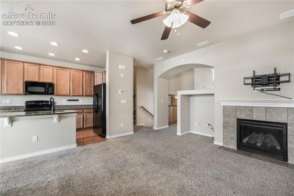 Image 19 of 50: Family room with fas fireplace, access to kitchen and walk out deck