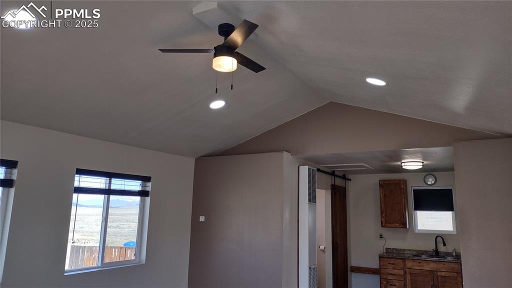 Image 12 of 38: Vaulted ceiling, recessed lighting, and ceiling fan.