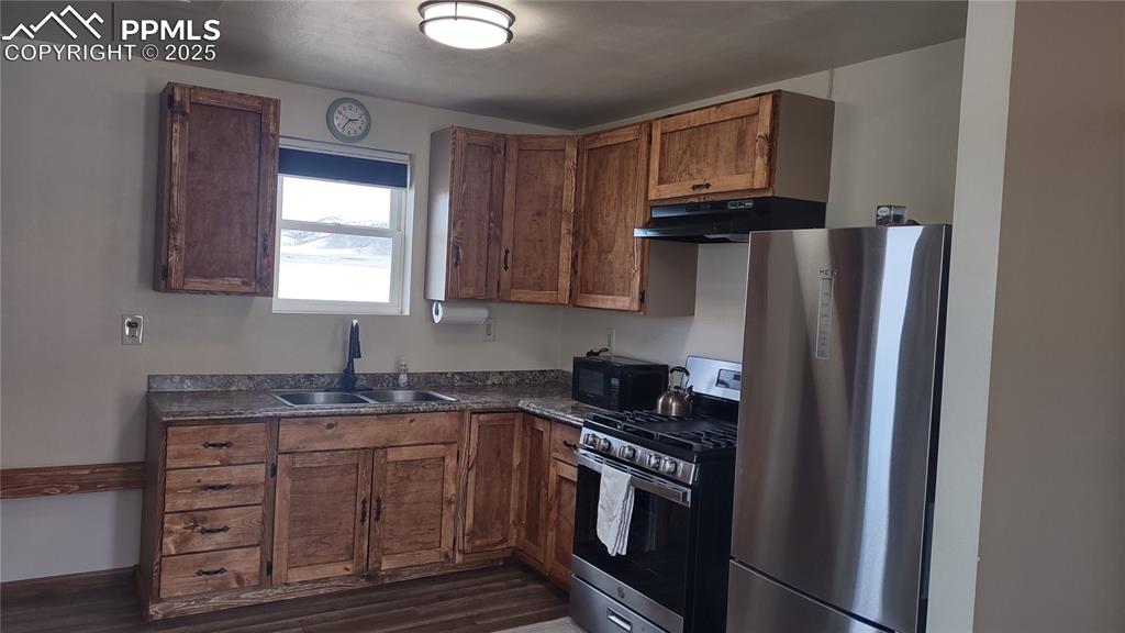 Image 15 of 38: Deep double sink and area left of cabinets for portable dishwasher, storage
