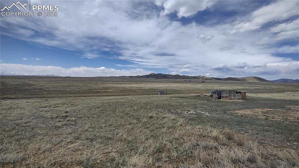 Image 31 of 38: Mountain view to north and one of the storage bins for wood.