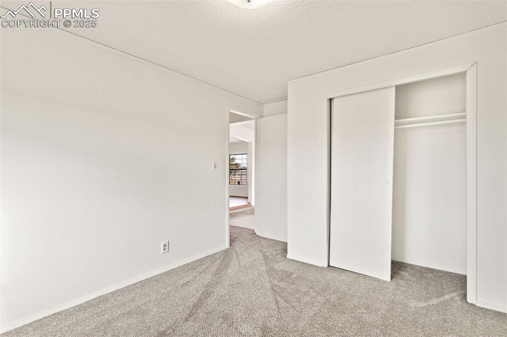 Image 29 of 50: secondary bedroom on main level with new carpet