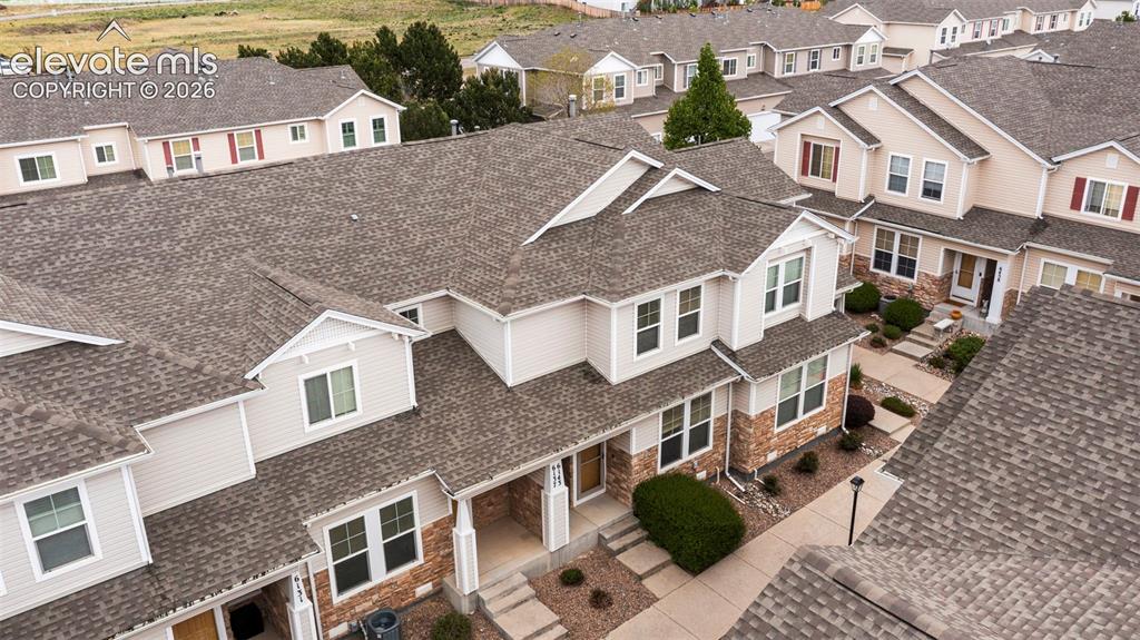 Image 1 of 30: Townhome exterior featuring tan siding, brick facade accents, multiple wind