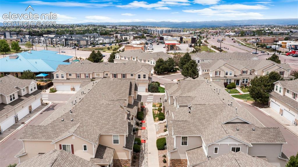 Image 12 of 30: Townhome community featuring neutral-toned siding, attached garages, and pi