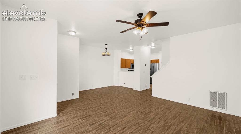 Image 16 of 30: Spacious room featuring wood-finish flooring, a ceiling fan with integrated