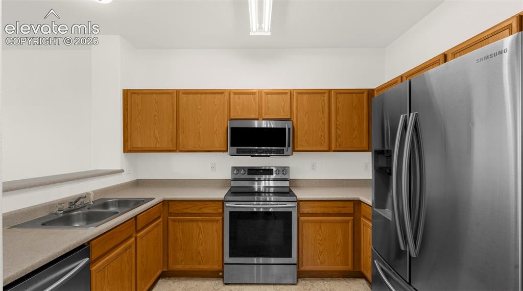 Image 18 of 30: Kitchen featuring wood-finish cabinetry, stainless steel appliances, and a 