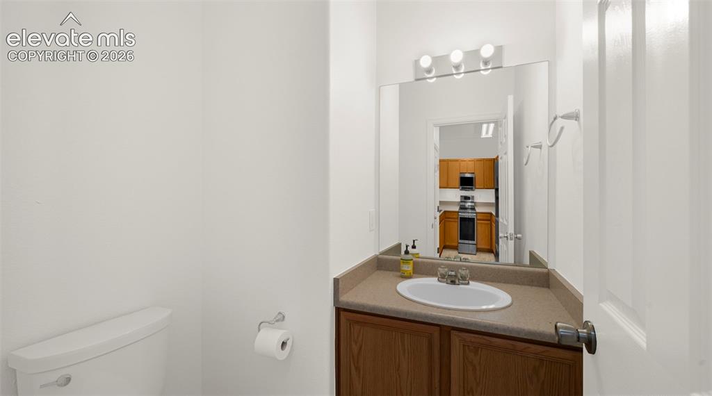 Image 20 of 30: Compact bath space featuring a vanity with a laminate countertop and an int
