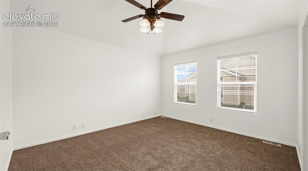Image 21 of 30: Spacious room featuring vaulted ceilings, a ceiling fan with integrated lig