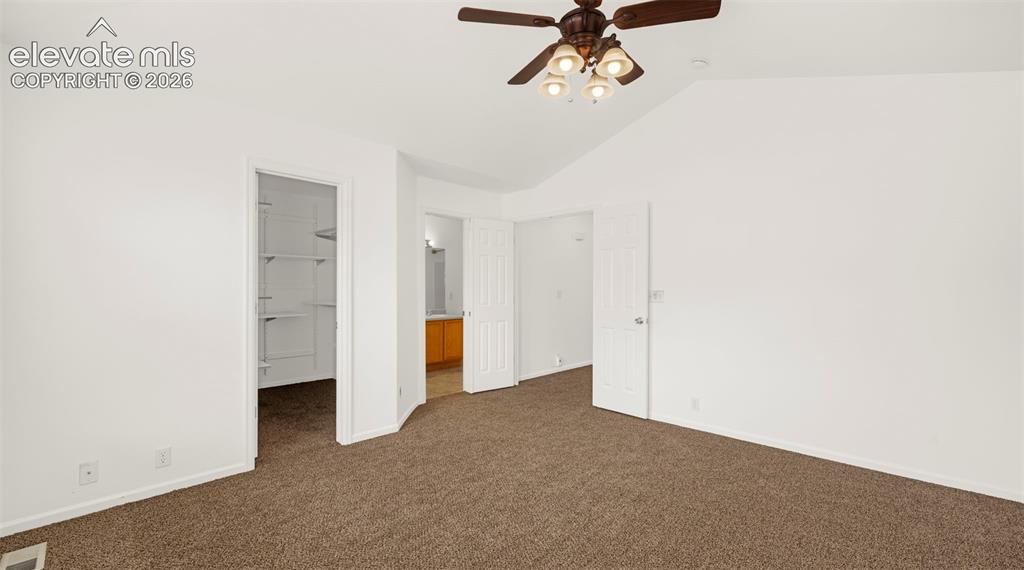 Image 22 of 30: Spacious interior room featuring vaulted ceilings, ceiling fan with integra