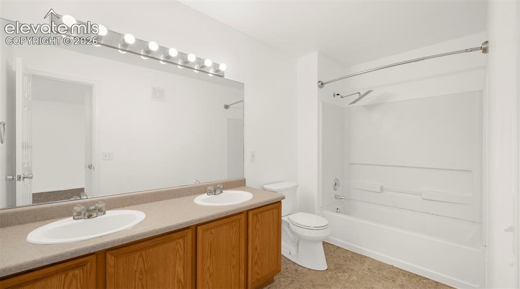 Image 23 of 30: Bathroom featuring a dual vanity with oak-finish cabinetry and a light-tone