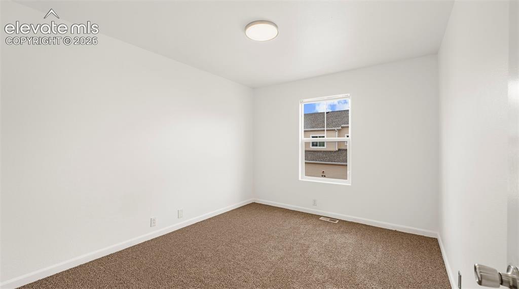 Image 26 of 30: Neutral wall color, brown carpet flooring, and a single window with white t