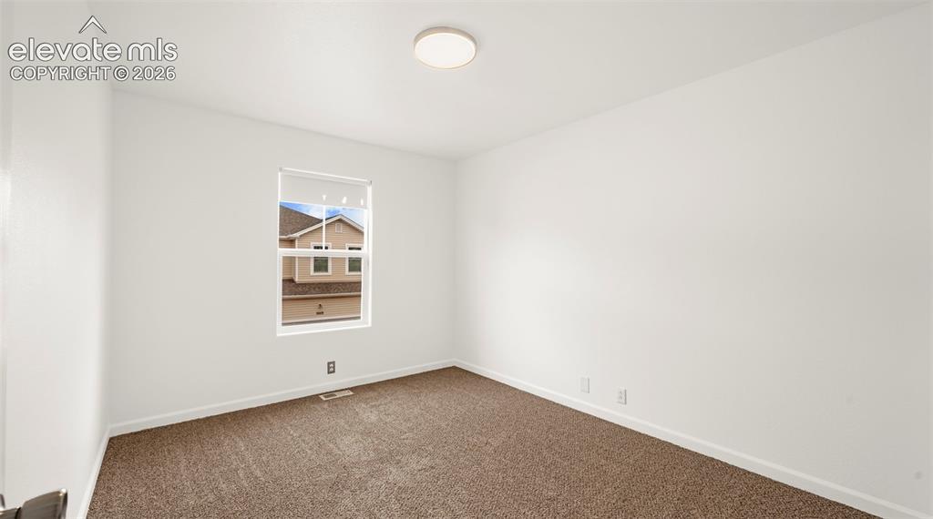 Image 27 of 30: Room featuring neutral-toned carpet, white walls, and white trim