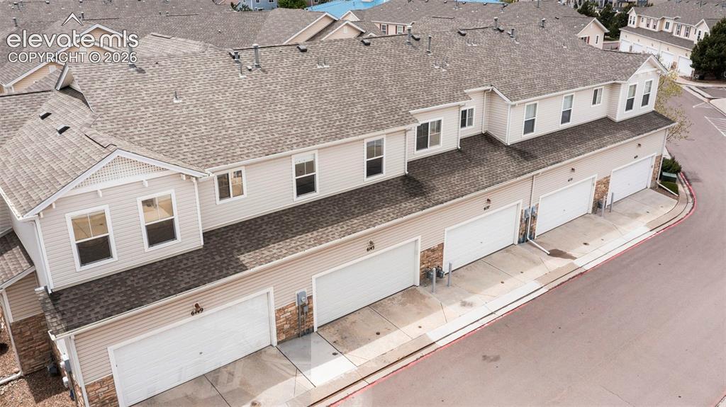 Image 9 of 30: Multi-level townhouse exterior featuring light-colored siding and a shingle