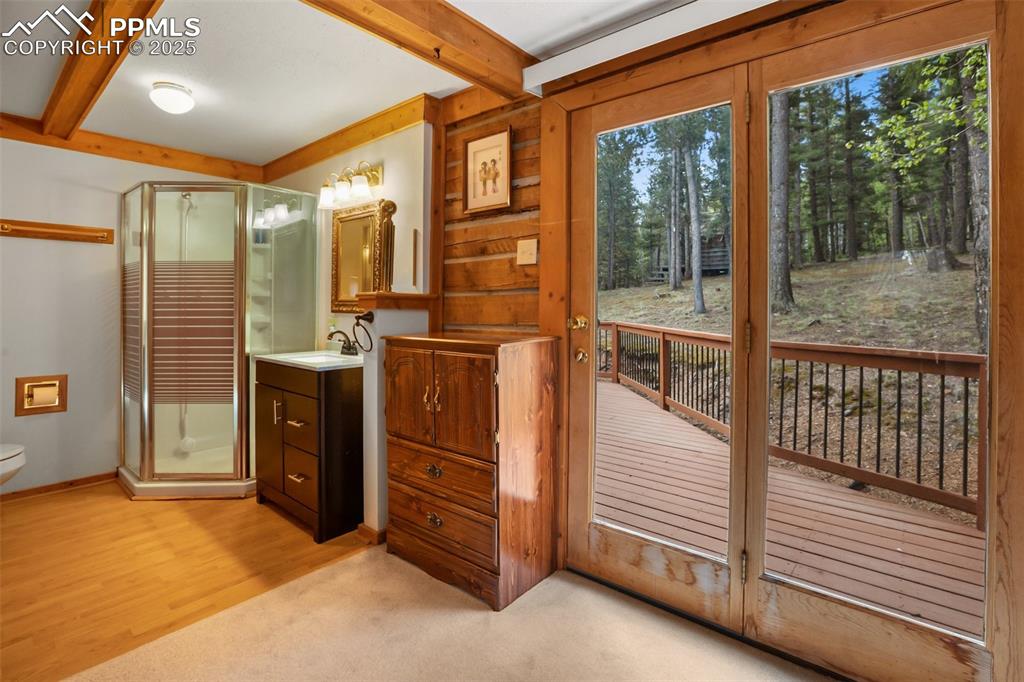 Image 22 of 36: Full bath featuring beam ceiling, a shower stall, vanity, toilet, and baseb