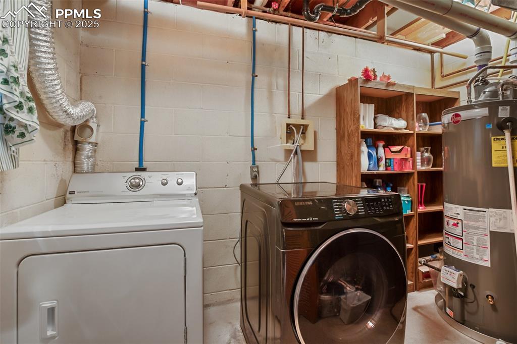 Image 31 of 36: Laundry area with gas water heater, separate washer and dryer, and concrete