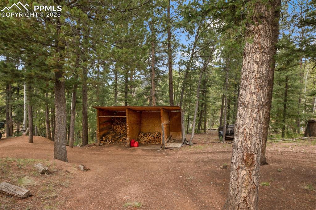 Image 36 of 36: View of outbuilding with a wooded view