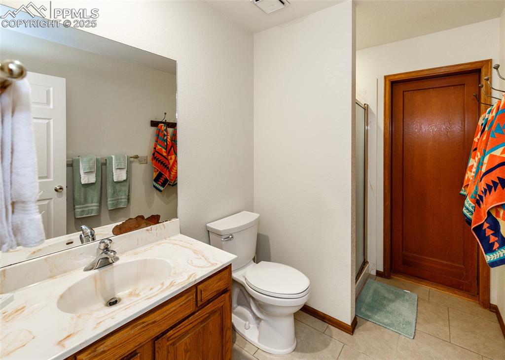 Image 10 of 41: 3/4 bathroom with light tile patterned floors, a stall shower, and vanity w