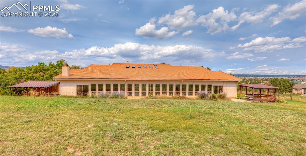 Image 2 of 41: Back of property with a chimney, a yard, and a patio