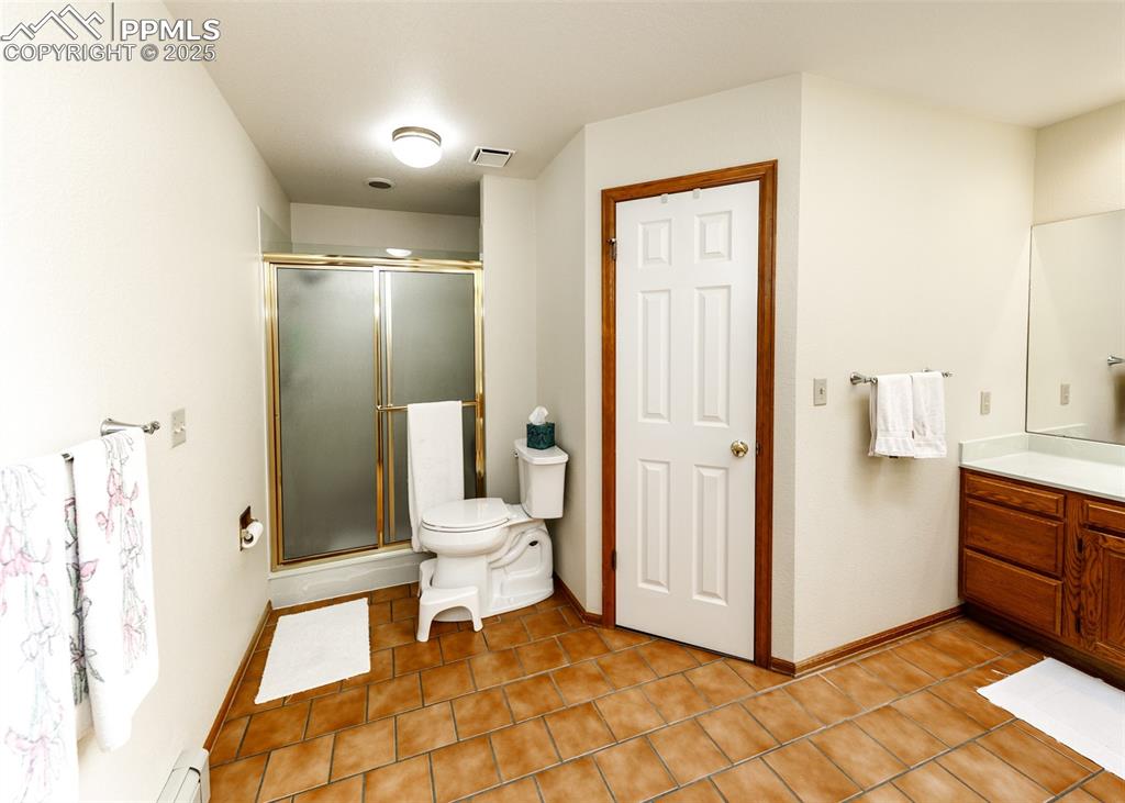 Image 26 of 41: Master Bathroom with vanity, a stall shower, light tile patterned flooring,
