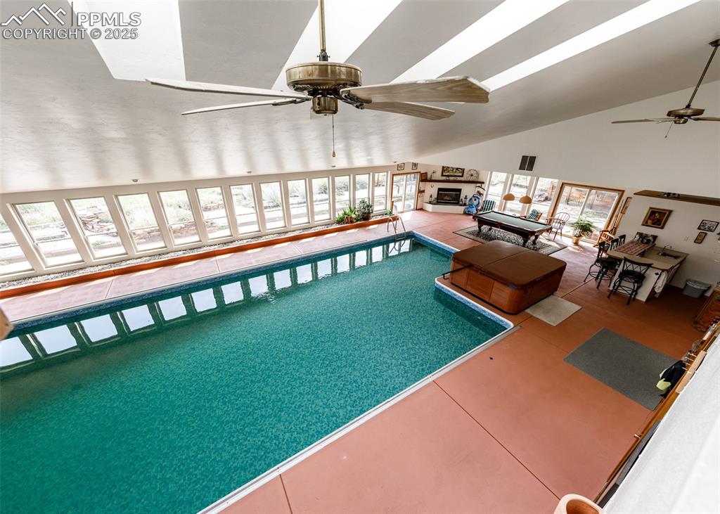 Image 28 of 41: View of pool with a sunroom and a ceiling fan from the Master bedrrom