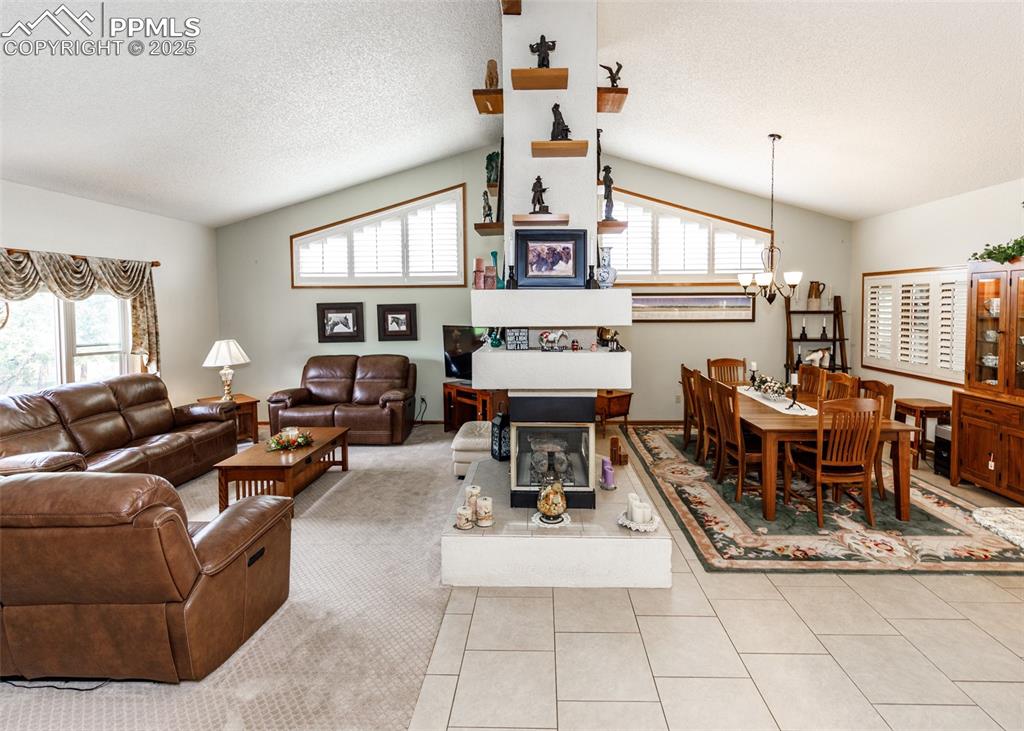 Image 41 of 41: Living area with a chandelier, light tile patterned floors, a textured ceil