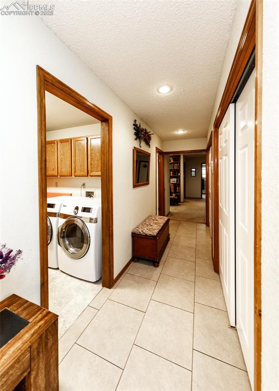 Image 8 of 41: Hallway with a textured ceiling, light tile patterned floors, and independe