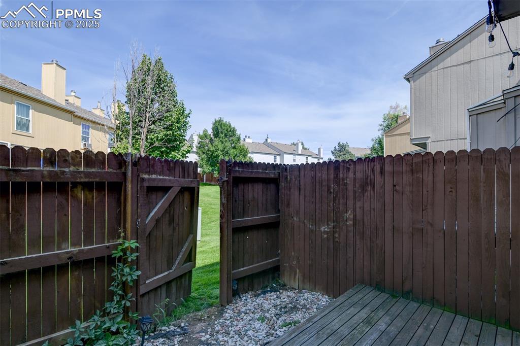 Image 30 of 34: Private fenced patio opens to greenspace.