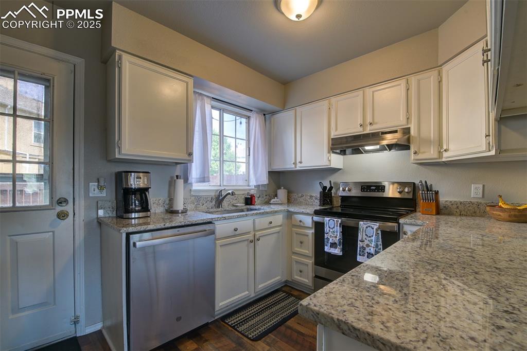 Image 8 of 34: Nice white kitchen with granite countertops. Stainless sink and appliances.