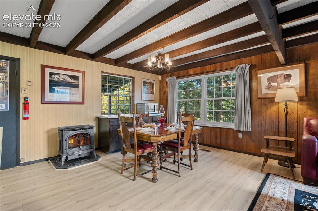 Image 8 of 38: Green brick fireplace and exposed beam ceilings.